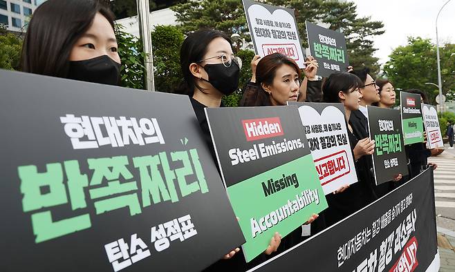 기후솔루션과 법률사무소 솔라리스가 28일 서울 서초구 현대자동차그룹 본사 앞에서 연 '현대자동차 철강 과소공시 그린워싱 신고 기자회견'에서 참가자들이 손팻말을 들고 있다. 연합뉴스&nbsp;