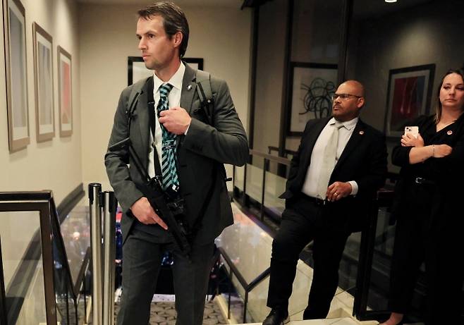 정장 차림의 요원이 25일(현지시간) 미국 워싱턴DC 워싱턴 힐튼호텔에서 열린 백악관 출입기자단 만찬 총격 시도 이후 계단 앞을 경계하며 소형 자동화기를 들고 있다. AFP 연합뉴스