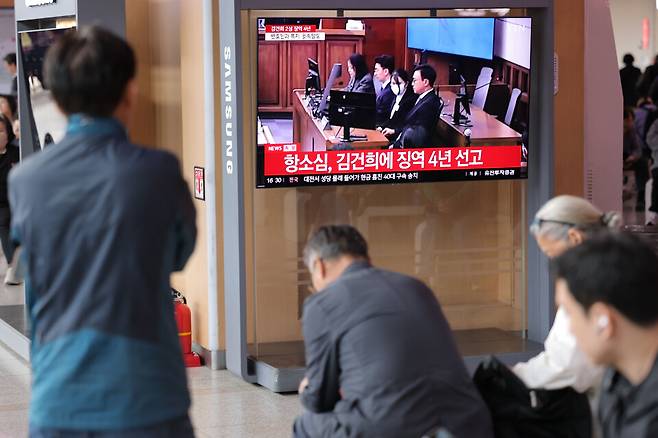 4월28일 서울역 대합실에서 시민들이 통일교 금품 수수와 도이치모터스 주가조작, 명태균 무상 여론조사 등의 혐의를 받는 김건희 여사 항소심 선고공판 생중계를 시청하고 있다. ⓒ연합뉴스