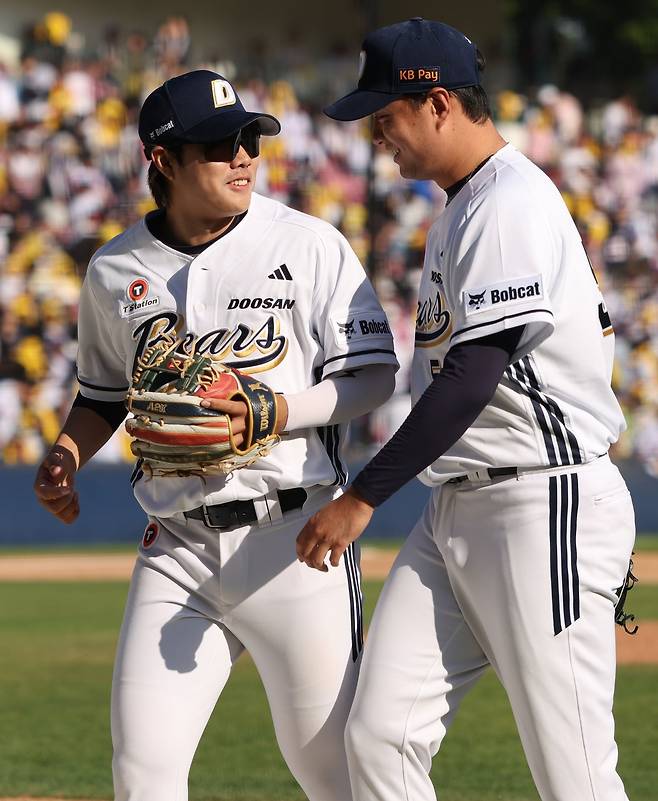 두산 이영하가 지난 26일 잠실 LG전에서 연장 10회초를 실점 없이 넘기며 안타성 타구를 잡은 박준순과 함께 웃고 있다.  두산 베어스 제공