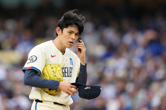 LA 다저스 사사키 로키가 25일 시카고 컵스와의 경기에서 자신의 피치컴 기기를 확인하고 있다. AP연합뉴스