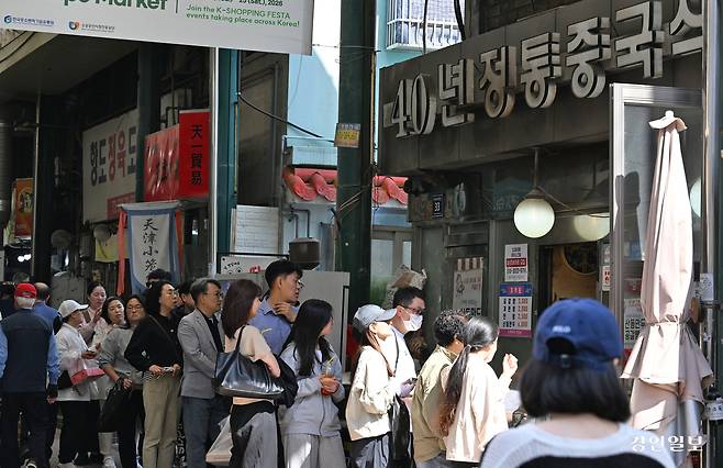 지난 24일 오후, 인천 신포국제시장의 대표 먹거리인 닭강정과 공갈빵을 맛보려는 손님들이 긴 줄을 서며 기다리고 있다. 2026.4.24 /조재현기자 jhc@kyeongin.com