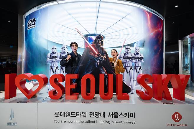 서울 잠실 롯데월드타워 전망대 ‘서울스카이’에 마련된 체험형 공간 ‘스타워즈  어보브 더 갤럭시’에서 모델들이 포즈를 취하고 있다.(사진제공=롯데물산)