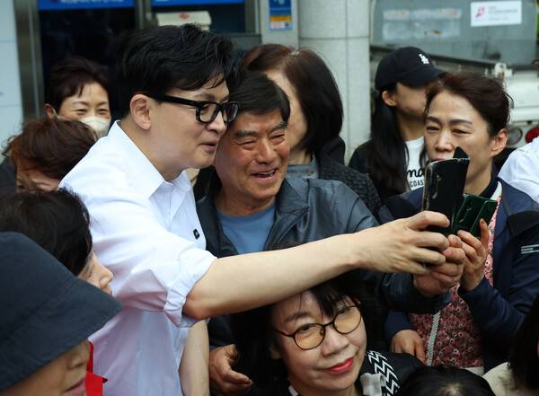 한동훈 전 국민의힘 대표가 14일 오후 부산 북구 만덕2동 행정복지센터를 찾아 전입신고를 마친 뒤 주민들과 사진을 찍고 있다. 2026.4.14. 연합뉴스