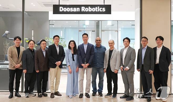 김민표(왼쪽 여섯째) 두산로보틱스 대표와 매디슨 황(왼쪽 다섯째) 엔비디아 수석 이사가 관계자들과 기념사진을 촬영하고 있다. (사진제공 = 두산로보틱스)