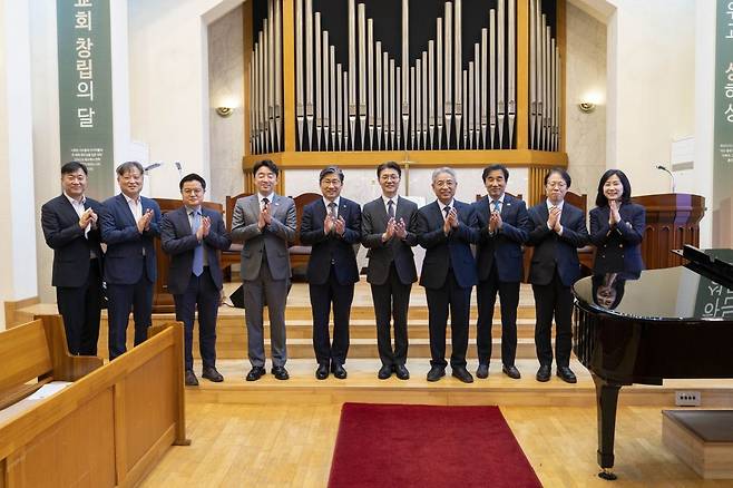 예배 후 관계자들이 박수를 치며 기념사진을 찍고 있다. 왼쪽 네 번째부터 강훈식 비서실장, 류 보좌관, 김두영 이철 목사. 교계사진기자단