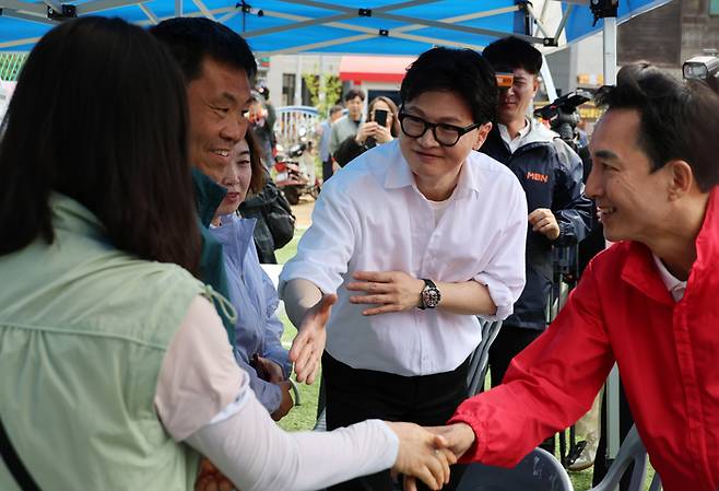 부산 북갑 국회의원 보궐선거에서 국민의힘 공천을 바라는 박민식 전 국가보훈부 장관과 무속소 출마를 공식화 한 한동훈 전 국민의힘 대표가 지난 26일 부산 구포초에서 열린 동문회 운동회에서 주민에게 인사를 하고 있다. [연합뉴스]