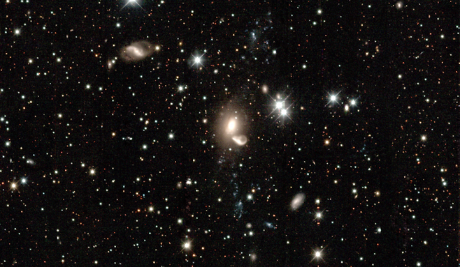 아벨 은하단 Abell 3574에 속한 합병 중인 은하 NGC 5291와 NGC 5291B의 모습(중심). NGC 5291의 아래위로 활 모양으로 지나가는 푸른색 작은 천체들로 이루어진 구조는 과거 이 은하가 다른 은하와 합병하는 과정에서 조석 작용으로 새로이 탄생한 조석 왜소은하(tidal dwarf galaxy)이다.[장서원/정만근(서울대)]