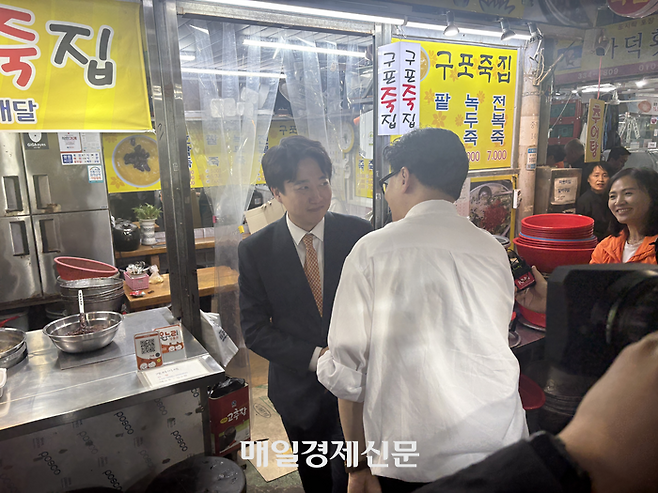 한동훈 전 국민의힘 대표와 이준석 전 국민의힘 대표가 부산 구포시장에서 만나 악수하고 있다. <신지윤 기자>