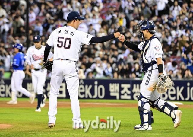 두산 이영하(왼쪽)와 윤준호가 29일 삼성전을 마친 뒤 주먹을 맞대고 있다. 관중석의 두산 팬들은 환호를 보내고 있다./잠실야구장=유진형 기자