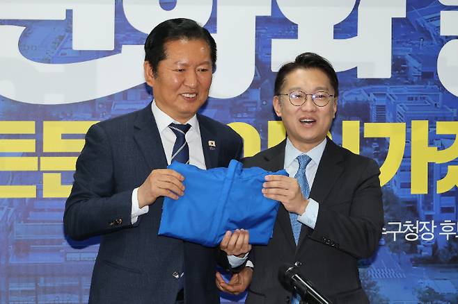 더불어민주당 정청래 대표가 24일 인천 연수구 정지열 인천 연수구청장 후보 선거사무소에서 열린 최고위원회의에서 김남준 계양을 보궐선거 후보에게 당 점퍼를 전달하고 있다. 연합뉴스