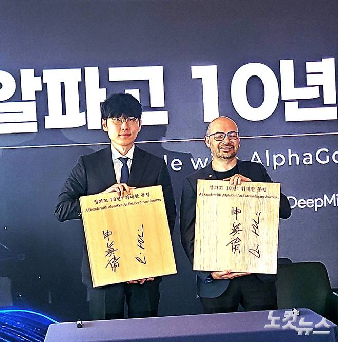 신진서 9단(사진 왼쪽)과 데미스 하사비스가 친필 사인을 한 바둑판을 들어보이고 있다. 동규기자