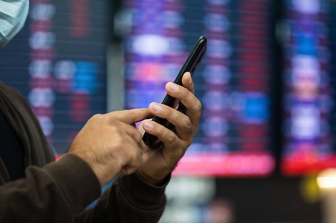 해외주식 계좌를 확인하는 개인 투자자의 모습. 생활비 부담이 커진 상황에서도 투자 자금을 쉽게 줄이지 않는 흐름이 이어지고 있다. 게티이미지