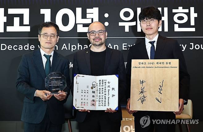'알파고 10년: 위대한 동행' (서울=연합뉴스) 김인철 기자 = 29일 서울 중구 웨스틴 조선호텔에서 열린 '알파고 10년: 위대한 동행'에서 양재호 한국기원 사무총장(왼쪽부터), 데미스 허사비스 구글 딥마인드 최고경영자(CEO), 신진서 9단이 선물 교환 후 기념 촬영을 하고 있다. 2026.4.29 yatoya@yna.co.kr