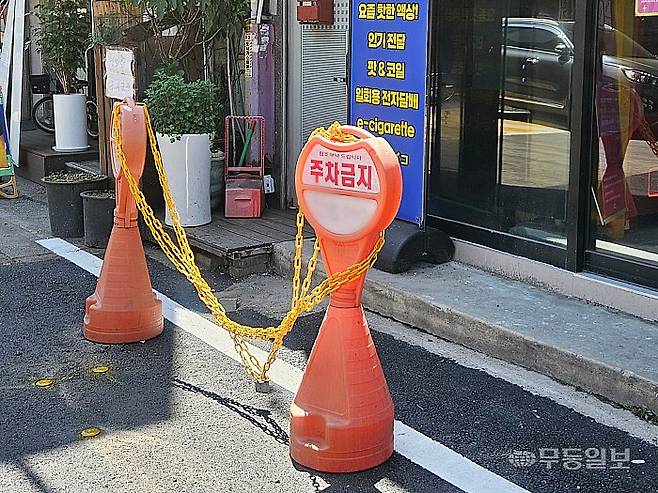19일 광주 서구 쌍촌동 한 골목에 물통과 꼬깔콘, 주차금지 표지판 등 노상 적치물이 놓여 있다.