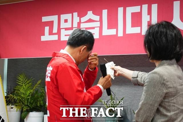 추경호 국민의힘 대구시장 후보가 30일 달성군 당원협의회 환송 행사에서 인사말을 하다 뒤돌아 서서 눈물을 훔치자, 부인 김희경 씨가 휴지를 건네고 있다. /추경호 선거 캠프