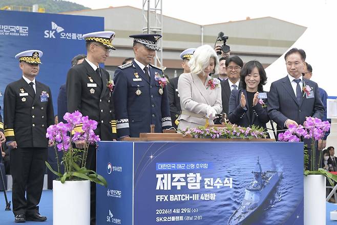 29일 경남 고성군 SK오션플랜트에서 열린 제주함 진수식에서 진영승 합참의장의 부인 정애숙 여사가 진수도끼를 이용해 진수줄을 자르고 있다. 해군 제공