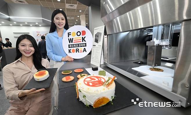 농림축산식품부와 코엑스가 주최한 '2025 푸드위크 코리아'가 29일 서울 강남구 코엑스에서 사흘 일정으로 열렸다. 모델들이 3D 식품 프린팅 기기 앞에서 포즈를 취하고 있다. 김민수기자 mskim@etnews.com