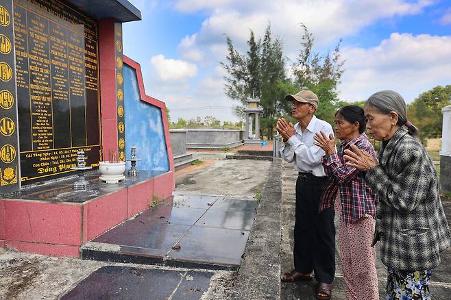 레륵(왼쪽)이 주이응이어 학살 희생자가 묻힌 집단묘지에서 아내 쩐티리(오른쪽)와 함께 희생자들의 명복을 빌고 있다. 가운데는 레륵 동생 레쯕의 아내 윈티탄.
