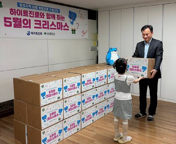 지난 27일 충북 청주 혜능보육원에서 열린 '하이트진로와 함께하는 5월의 크리스마스' 전달식에서 김진영 청주공장장이 한 아동에게 선물을 전달하고 있다. [사진=하이트진로]