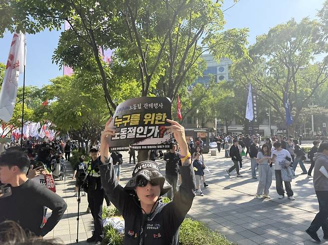 한 민주노총 공공운수노조 조합원이 '누구를 위한 노동절인가'라고 적힌 포스터를 들고 있다. '노동절 관제행사를 반대하며 노동해방을 위해 행동하는 활동가 모임' 소속인 그는 양경수 민노총 위원장이 대회사 선언을 위해 무대에 오르자 "양경수는 물러나라"며 기습 항의 시위를 벌였다./최영총 기자