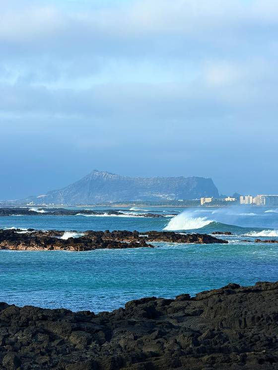 Seongsan Ilchulbong seen over the breakers on a windy April 4. [JIM BULLEY]