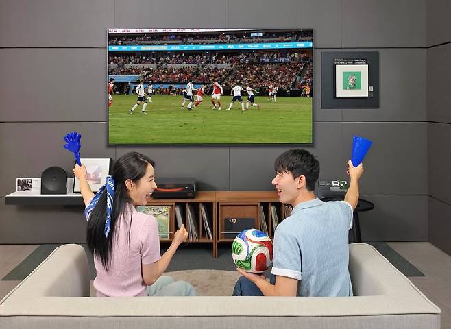 삼성전자 모델이 'AI 축구 모드'가 적용된 2026년형 '더 프레임 프로' TV로 축구 경기를 시청하고 있다. 삼성전자 제공