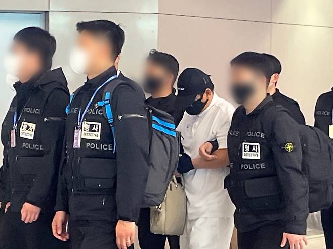 ‘마약왕’ 박왕열에게 마약을 공급한 혐의를 받는 최모(51)씨가 1일 인천국제공항 입국장에서 경찰에 호송되고 있다. 박다운 수습기자