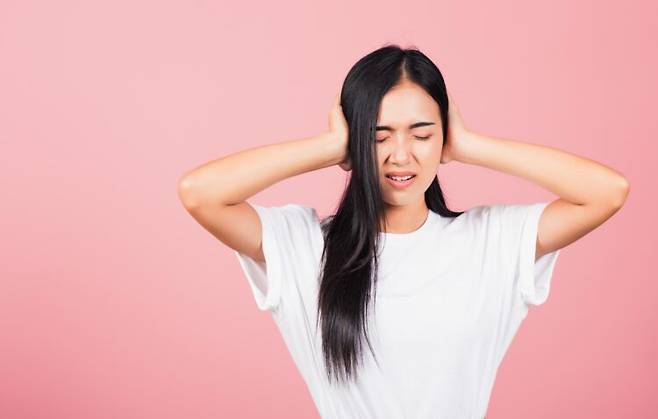 양손으로 귀를 막고 눈을 감은 채 민감하게 반응하는 여성. 특정 항우울제 복용 이후 귀울림 증상이 나타날 수 있다. 사진=게티이미지뱅크