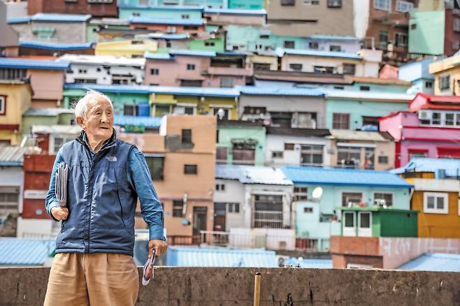 부산 사하구 감천문화마을 ‘날다람쥐’로 통하는 오광봉씨가 신문 뭉치를 들고 섰다. 평생 골목길과 가파른 계단을 오르내리며 신문을 배달한 덕에 건강은 요즘도 자신 있다. /주민욱 영상미디어 기자