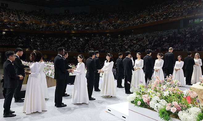 신랑신부들이 무대에 올라 축복예식에 참여하고 있다.