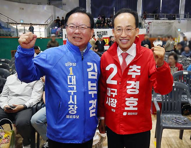 김부겸 더불어민주당 대구시장 후보(왼쪽)와 추경호 국민의힘 대구시장 후보가 지난 1일 대구 북구 시민체육관에서 열린 한국노총 노동절 기념대회에서 만나 악수한 뒤 파이팅을 외치고 있다. 뉴스1