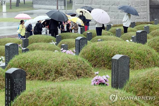 빗속에서 듣는 오월의 이야기 (광주=연합뉴스) 김혜인 기자 = 제46주년 5·18 민주화운동 기념일을 15일 앞둔 3일 광주 북구 운정동 국립5·18민주묘지에서 곡성초 학생들이 오월 열사에 관한 이야기를 듣고 있다. 2026.5.3 2026.5.3 in@yna.co.kr
