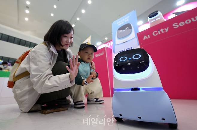 서울 중구 동대문디자인플라자(DDP) 아트홀에서 열린 서울AI페스티벌 2026에서 엄마와 아이가 가정용 생활 반려로봇 '케미프렌즈'와 인사하고 있다.ⓒ뉴시스