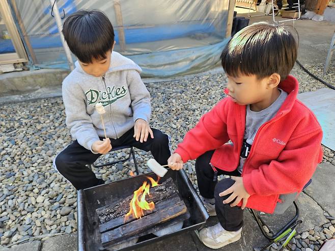 심정섭씨 자녀들이 지난 3월 충북 괴산 할아버지 댁 마당에서 마시멜로를 구워 먹고 있다. 심씨 제공