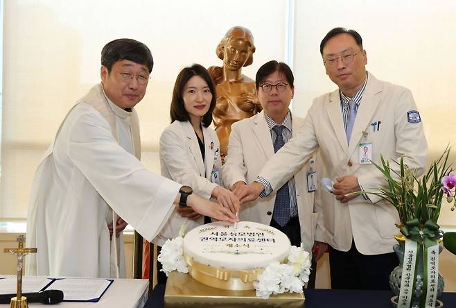 27일 가톨릭대학교 서울성모병원 본관에서 열린 ‘권역 모자의료센터’ 개소식·축복식에 참석한 박인양(맨 오른쪽) 교수가 축하 케이크를 자르고 있다.[서울성모병원 제공]