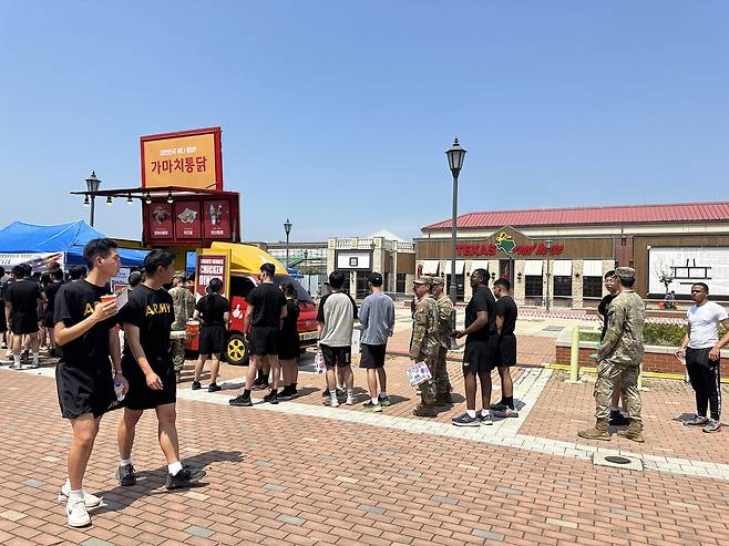 가마치통닭이 지난 2024년 6월 경기도 평택 험프리스 미군기지에서 열린 한미친선주간행사에서 군장병들에게 치킨과 음료를 제공하는 모습.  [가마치통닭 제공]