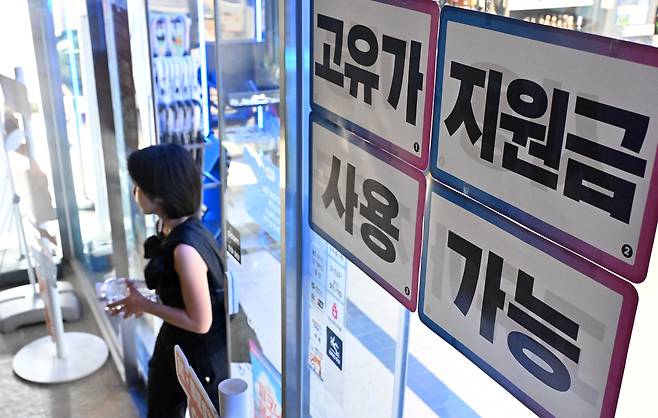고유가 피해지원금 1차 지급 시작일인 지난달 27일 오전 서울시 내 한 편의점에 피해지원금 사용처를 알리는 안내문이 부착돼 있다.  임세준 기자