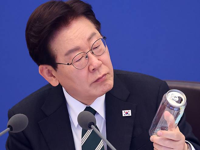 이재명 대통령이 28일 청와대에서 열린 국무회의 겸 비상경제점검회의에서 캔시머 용기를 살펴보고 있다. 뉴시스