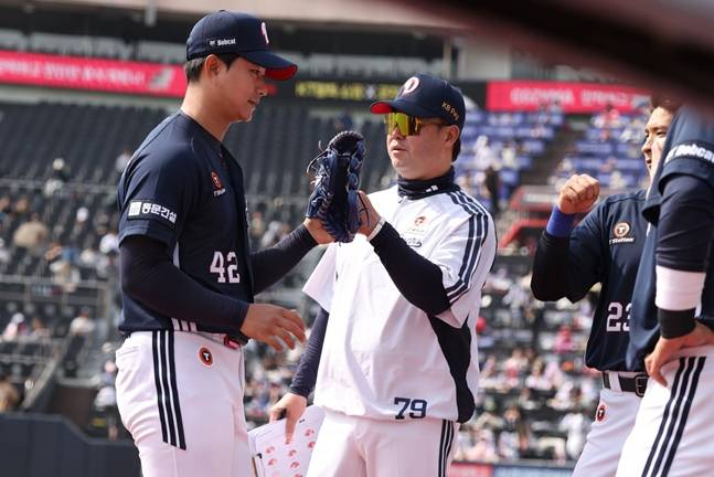 지난 3월 시범경기에서 최지강(왼쪽)을 맞이하는 손지환 코치. /사진=두산 베어스