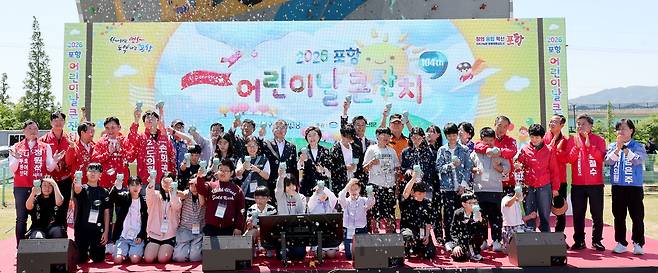 모범 어린이 대표와 내빈, 지방선거에 출마하는 지역의 예비후보들이 함께 축하 퍼포먼스를 하고 있다.