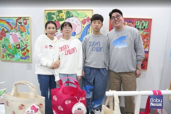 제6회 부산국제어린이청소년아트페어 단체전에 참여한 천예온, 천지온 작가 가족들이 자신들의 부스에서 기념촬영을 하고 있다. 이들 작가 가족들은 '오니오니'라는 자신만의 캐릭터를 개발해 그림을 그리고, 각종 굿즈도 만들고, 프린팅 옷도 제작해 관람객들에게 선보이고 있다. ⓒ베이비뉴스​
