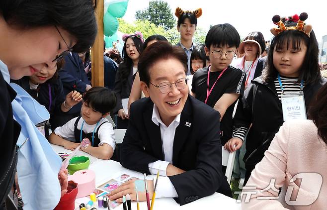 이재명 대통령과 김혜경 여사가 5일 청와대 녹지원에서 열린 2026 어린이날 초청행사에 참석한 어린이들과 함께 손등에 페이스 페인팅을 받고 있다. 2026.5.5 ⓒ 뉴스1 허경 기자