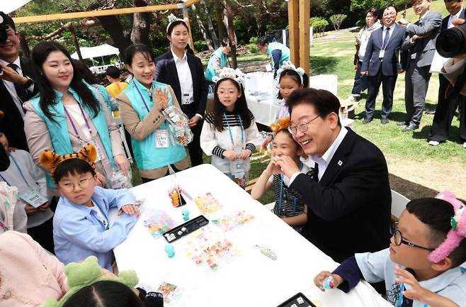 이재명 대통령이 5일 청와대 녹지원에서 열린 어린이날 초청행사에서 참석 어린이와 키캡 만들기 체험 후 기념촬영을 하고 있다. 2026.5.5 [청와대통신사진기자단] 연합뉴스