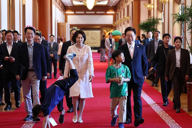 이재명 대통령과 김혜경 여사가 어린이날인 5일 청와대에서 열린 ‘2026년 104회 어린이날 청와대 초청행사’에 참석한 어린이들과 대화를 나누며 함께 이동하고 있다. 청와대사진기자단
