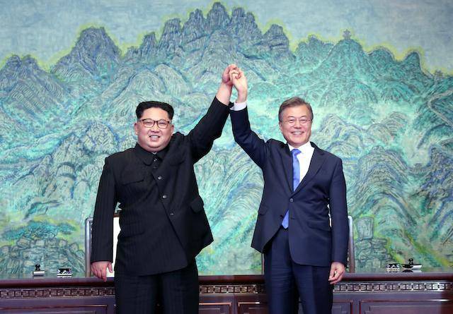 문재인(오른쪽) 당시 대통령과 김정은 북한 국무위원장이 2018년 4월 27일 판문점에서 '판문점 선언문'에 서명한 뒤 맞잡은 손을 들어올리고 있다. 연합뉴스