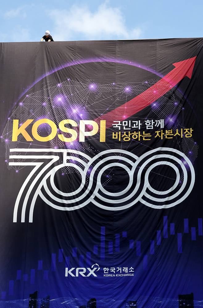 ▲ 코스피가 사상 처음으로 장중 7000선을 넘어선 6일 서울시 영등포구 KRX 한국거래소 외벽에 코스피 7000선 돌파를 기념하는 대형 현수막이 설치되고 있다. 이날 코스피는 전 거래일 대비 447.57포인트(6.45%) 오른 7384.56으로 거래를 마쳤다. /이재민 기자 leejm@incheonilbo.com
