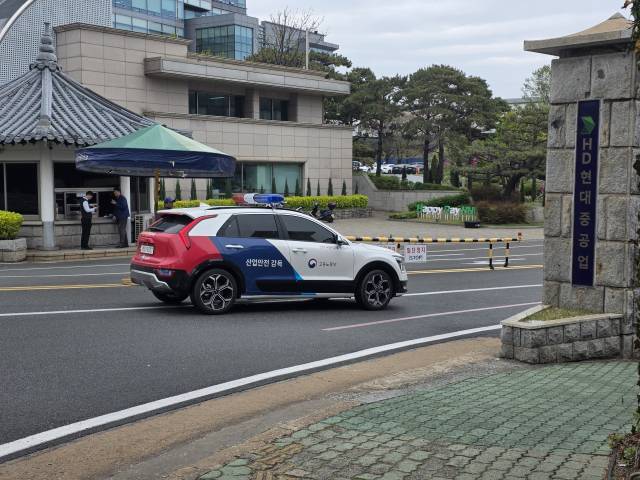 고용노동부 산업안전감독 차량이 6일 오전 ‘홍범도함 화재’ 사망 사고와 관련한 압수수색을 위해 울산 동구 HD현대중공업 정문을 통과하고 있다. 이날 경찰과 노동부는 인력 60명을 투입해 본사와 협력업체 등을 대상으로 동시 압수수색을 진행하며 본격적인 강제수사에 착수했다. 오상민 기자