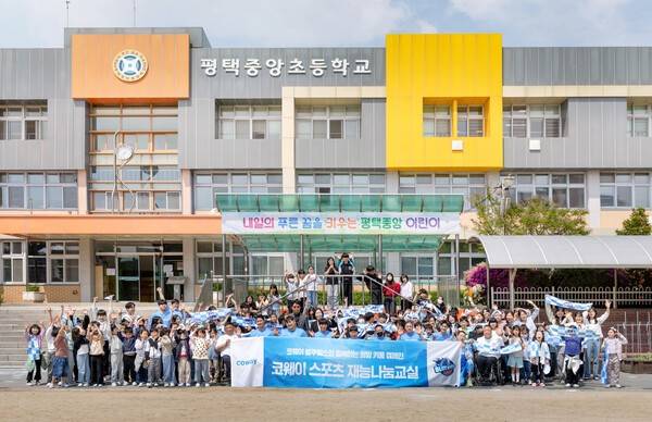 코웨이 블루휠스 휠체어농구단 선수 및 관계자들이 평택중앙초등학교 학생들과 휠체어농구 체험교실 진행을 기념해 단체사진을 촬영하고 있다. [출처=코웨이]
