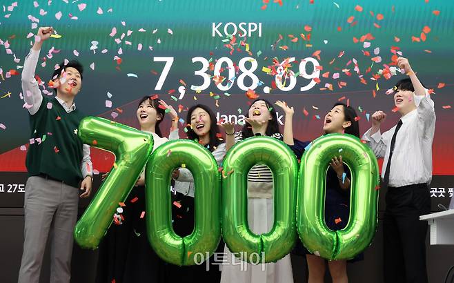 코스피 지수가 7000선을 돌파한 6일 서울 중구 하나은행 딜링룸 전광판 앞에서 딜러들이 축하 세리머니를 하고 있다. 고이란 기자 photoeran@